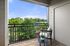 Charming balcony with stylish seating and lush green view, perfect for relaxation.