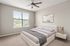 Bright and airy bedroom with a cozy bed, modern artwork, and a scenic view through large windows.