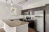 Modern kitchen with granite countertops, sleek stainless steel appliances, and stylish pendant lighting, offering a chic and functional cooking space.