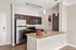 Modern kitchen with elegant granite countertops, stainless steel appliances, and stylish pendant lighting.