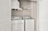 Modern laundry nook featuring sleek white washer and dryer beneath stylish shelving, perfect for organized living.