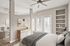 Bright and airy contemporary bedroom with large windows, elegant decor, and an adjoining cozy living space.
