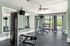 Modern fitness center with sleek equipment, natural light, and lush outdoor views.