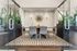 Modern conference room with elegant glass doors, stylish chairs, and chic wall decor, highlighted by lush green plants.