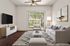 Modern living room with sleek decor, featuring a plush sofa, chic armchair, and contemporary art, opening to a serene garden view.