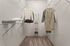 Spacious walk-in closet with elegant hanging space and organized shelves, perfect for stylish living.