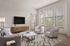 Bright and modern living room with plush seating, stylish wooden TV console, and large windows inviting natural light.