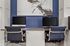 Modern home office setup with dual sleek computer stations, chic navy chairs, and elegant artwork on a rich blue accent wall.