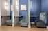Chic and modern workspace with cozy blue and gray booth seating, accented by elegant wall sconces and floral artwork.