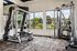 Bright and modern fitness center with Precor and HOIST exercise equipment, offering a spacious workout environment with outdoor views.