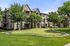 Charming apartment complex surrounded by lush greenery and a manicured garden, ideal for tranquil living.