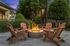 Inviting outdoor patio with cozy Adirondack chairs around a glowing fire pit, surrounded by lush greenery and elegant architectural details.