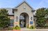 Inviting leasing center with a charming stone facade, lush greenery, and a welcoming arched entrance.