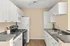 Chic and modern kitchen with sleek countertops, white cabinetry, and stainless steel appliances, perfect for culinary enthusiasts.