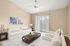 Bright and inviting living room with contemporary decor, featuring a plush white sofa, elegant coffee table, and large window with vertical blinds for abundant natural light.