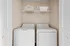 Convenient laundry room with modern washer and dryer, enhanced by smart storage in a cozy apartment space.