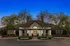 Charming clubhouse facade with elegant features and lush landscaping under a twilight sky.