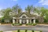 Charming residential property with elegant entrance, surrounded by lush greenery and well-manicured shrubs.