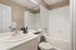 Modern bathroom design featuring elegant white fixtures, a spacious bathtub, and a large vanity mirror with stylish decor accents.