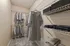 Spacious walk-in closet with organized wire shelving showcasing neatly hung clothing and storage boxes.