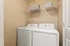 Modern laundry room with sleek washer and dryer, built-in shelving, and neutral decor.