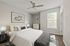 Bright and modern bedroom with elegant decor, featuring a comfortable bed, stylish artwork, and large window for natural light.