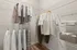 Spacious walk-in closet with elegant shelving and ample hanging space, showcasing neatly organized clothing and luxurious folded towels.