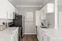 Modern kitchen with sleek white cabinetry, stainless steel appliances, and elegant countertops, perfect for culinary enthusiasts.