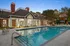 Elegant poolside retreat at a luxury apartment complex, featuring a beautifully lit swimming pool and stylish clubhouse with classic architecture.