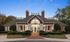 Elegant and inviting clubhouse exterior with classic architecture, manicured landscaping, and ambient lighting.