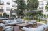 Luxurious outdoor lounge area with cozy seating, fire pit, and lush greenery, perfect for relaxation and entertaining.