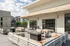 Elegant rooftop terrace featuring modern outdoor seating and a cozy fire pit under a stylish awning, offering a scenic view of the urban skyline.