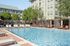 Luxurious apartment outdoor swimming pool with sun loungers and shaded cabanas, perfect for relaxation.