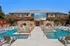 Luxurious outdoor pool area featuring stylish cabanas and a vibrant movie screen backdrop, perfect for relaxation and entertainment.
