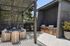 Chic outdoor patio with modern BBQ grills and stylish seating under a sleek pergola, perfect for entertaining.