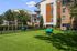Modern apartment complex with spacious outdoor recreational area, featuring green open spaces and thoughtfully designed play structures.