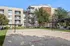 Modern apartment complex with sandy volleyball court, lush greenery, and inviting outdoor lounge area.