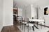 Modern dining area with sleek furniture, hardwood floors, and a cozy open-plan kitchen.