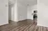 Contemporary apartment interior with sleek wood flooring, modern kitchen appliances, and minimalist design.