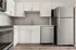 Sleek modern kitchen with stainless steel appliances, white cabinetry, and elegant tiled backsplash.