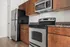 Modern kitchen with sleek stainless steel appliances and elegant wood cabinetry, showcasing a stylish and functional design.