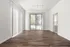 Bright and airy apartment living room with beautiful hardwood floors and large sliding glass doors leading to a serene outdoor view.