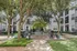 Charming apartment courtyard featuring lush greenery, cozy seating areas, and elegant trees offering shade and tranquility.