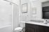 Elegant bathroom with modern fixtures, featuring a sleek granite countertop and stylish dark wood cabinetry, ideal for luxurious living.