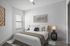 Elegant bedroom with modern decor, featuring plush bedding, stylish artwork, and ample natural light.