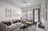 Chic and modern living room featuring a comfortable beige sofa, stylish armchair, elegant artwork, and abundant natural light through large windows.