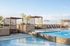 Luxurious rooftop swimming pool with modern lounge chairs and shaded cabanas, perfect for relaxation and leisure.