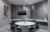 Modern conference room featuring a sleek round table, executive chairs, and contemporary decor with a stylish wall design.