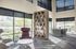 Modern office space with floor-to-ceiling windows, elegant shelving, and sleek conference area offering a scenic garden view.