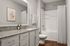 Elegant modern bathroom with granite countertop, stylish fixtures, and soft lighting.